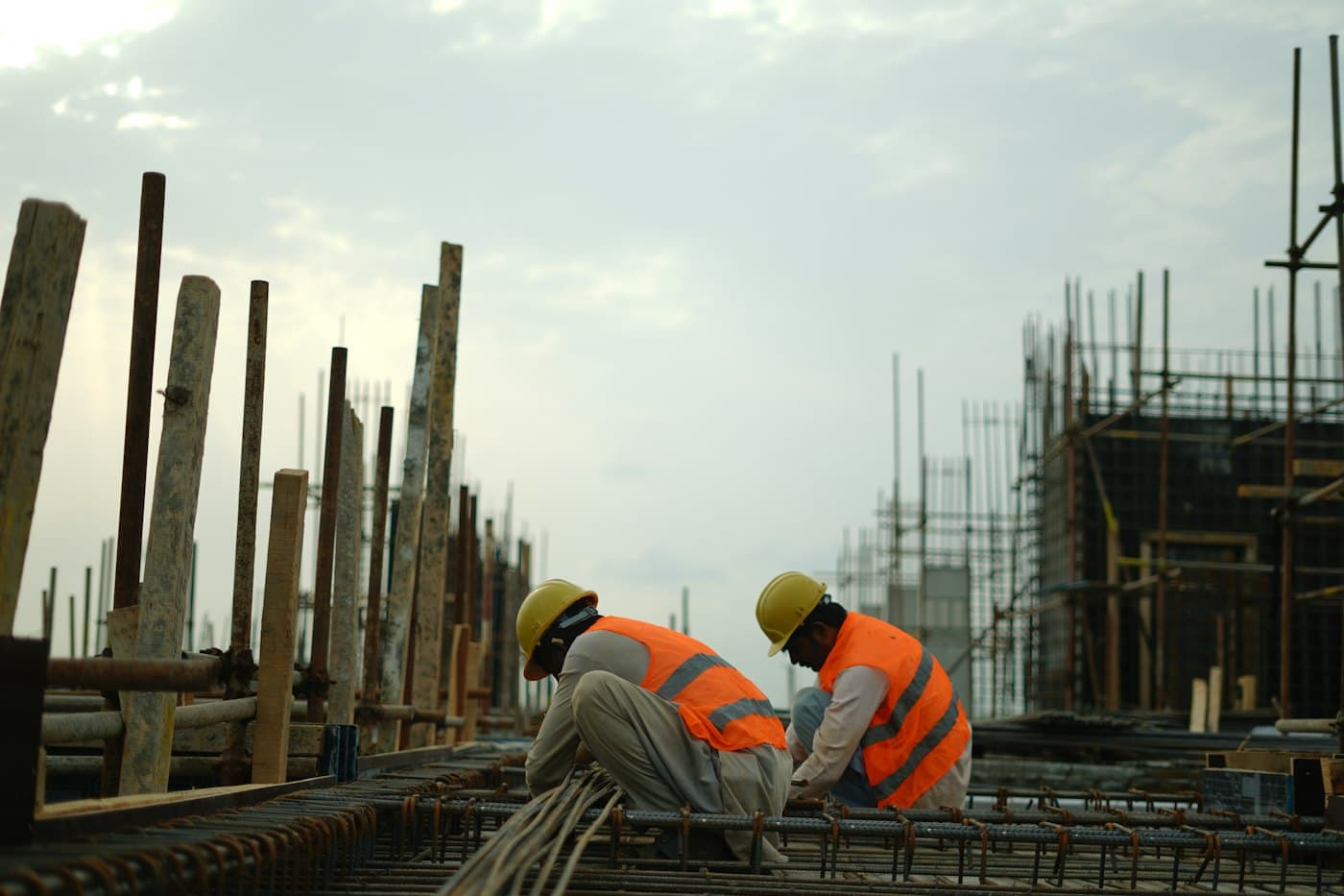 Trabajadores con casco y chaleco en una obra en construcción